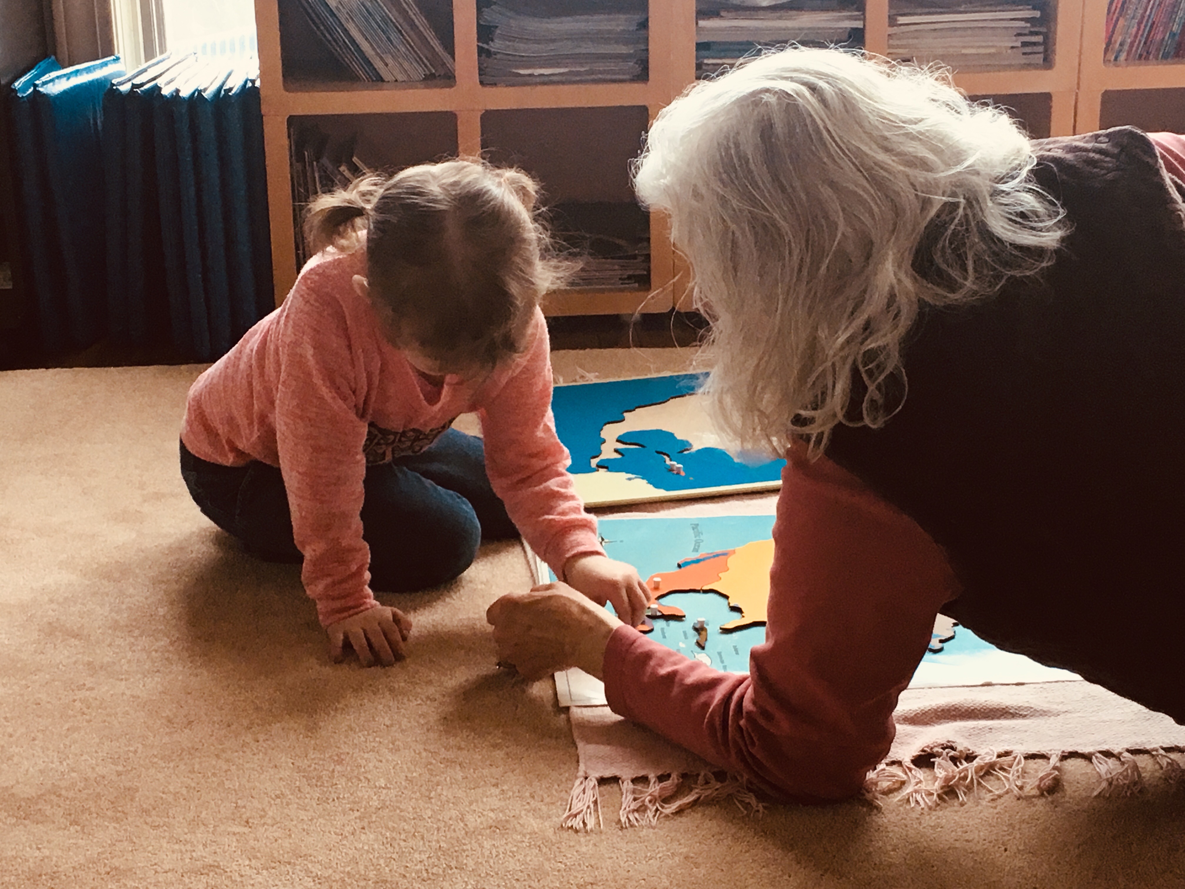 Ellie, age 5, working the North American puzzle map with Mrs. Dyer.